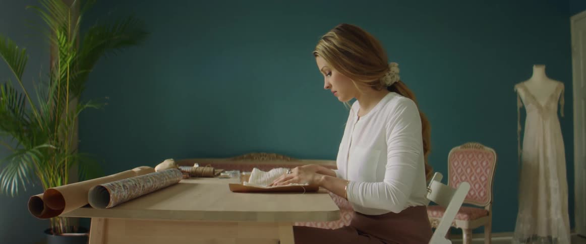 A woman is touching fabric at the table