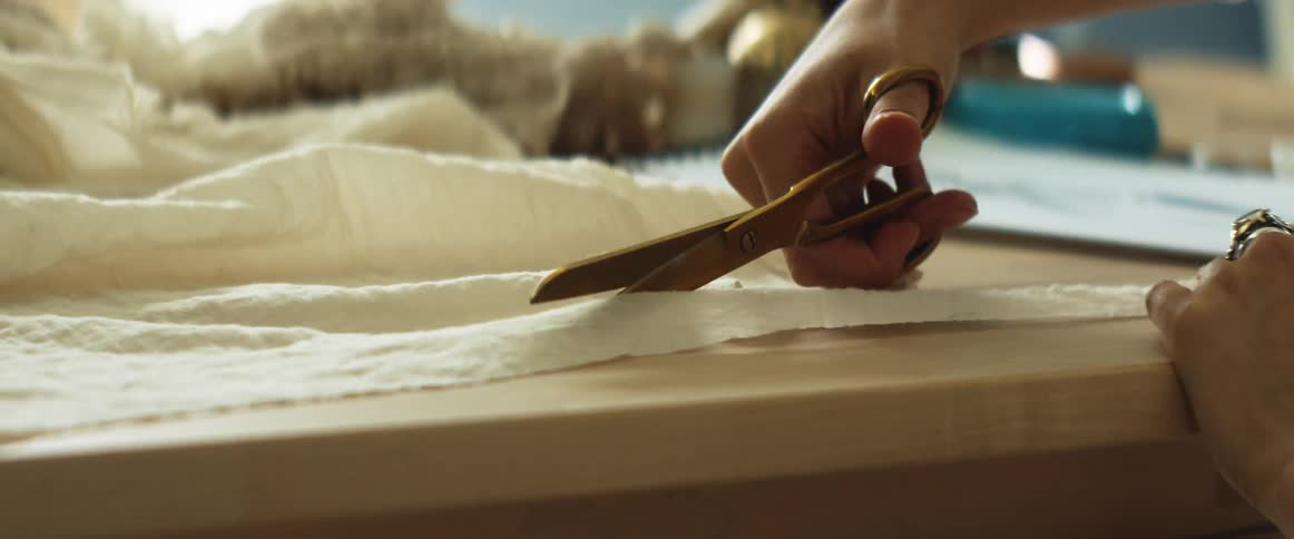 A woman uses scissors to cut a piece of fabric