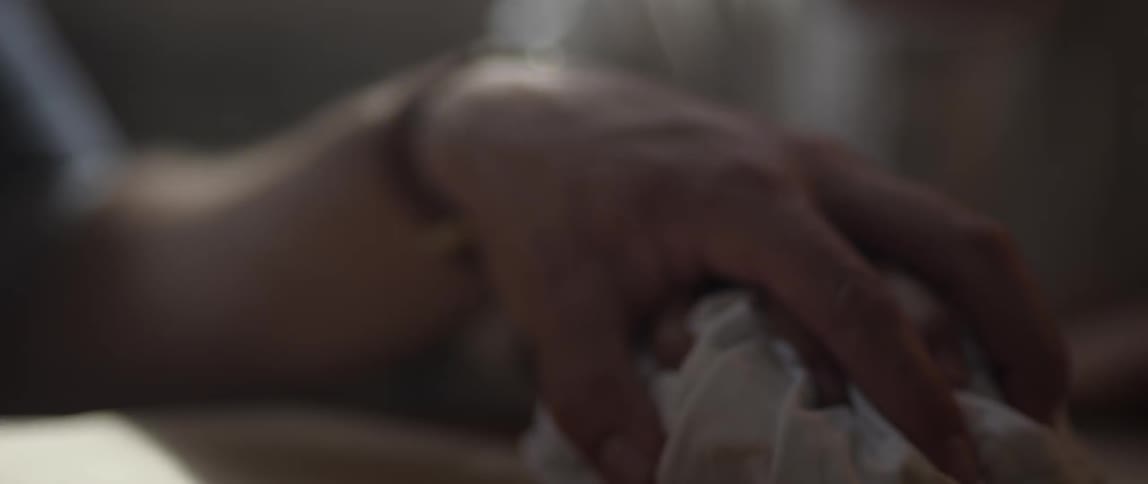 A person grabs a bundle of cloth then another person places their hand on top of theirs, then moves the cloth around