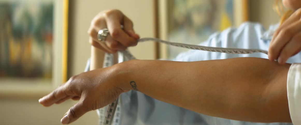 A woman measuring the arm on another woman