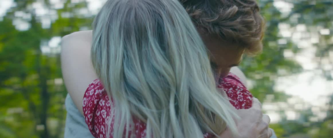 Two people kissing in a park