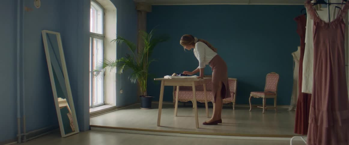 Clothes designer taking photos of a sketch over her desk