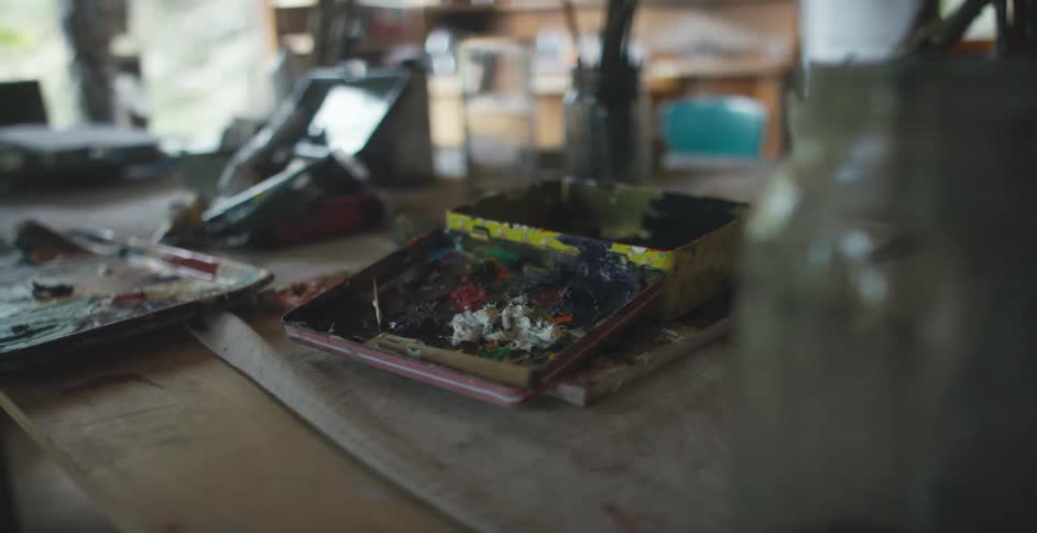 The table is covered with painting supplies