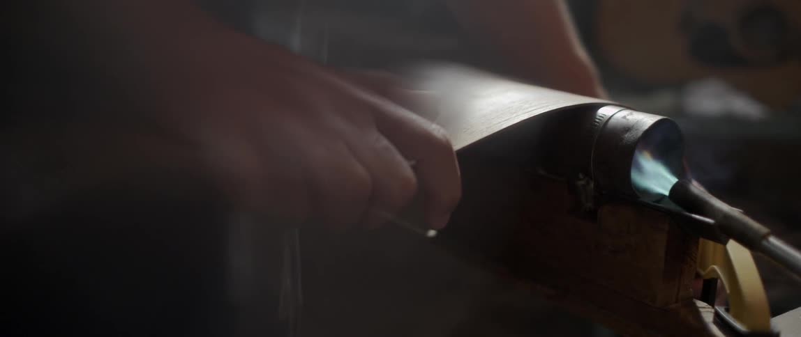 Person forming a piece of wood with the use of fire