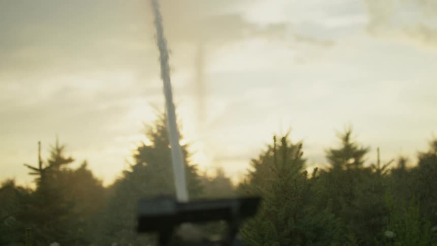 Close up of water spraying out of a sprinkler system in a rural area