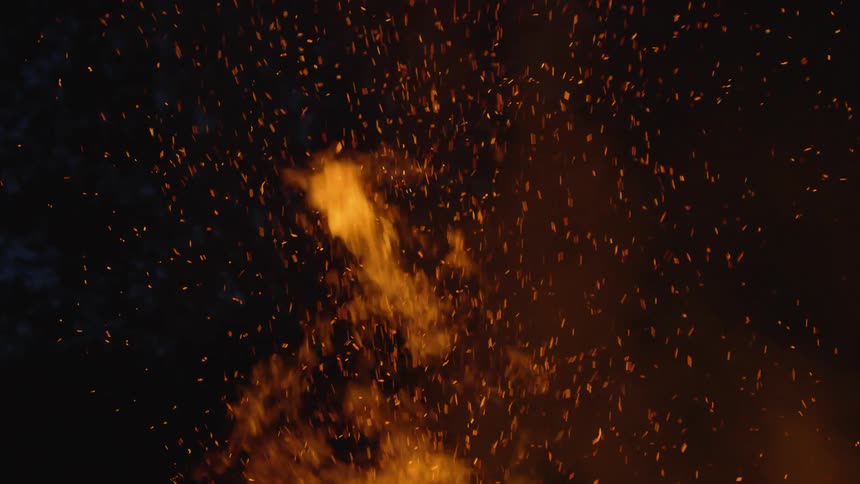 A fire sends embers in the night air