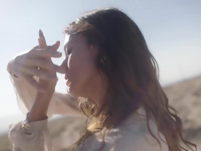 A woman moving her hands as she dances outdoors