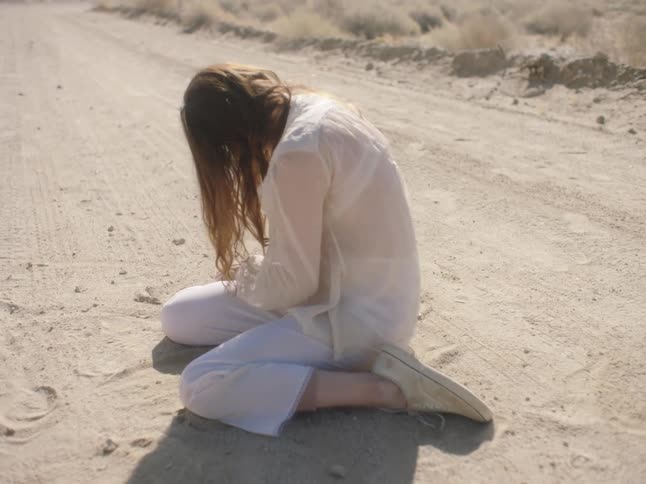 A woman crying in the middle of the desert