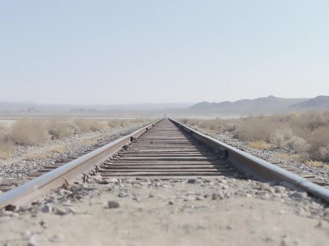 The train tracks run through the desert