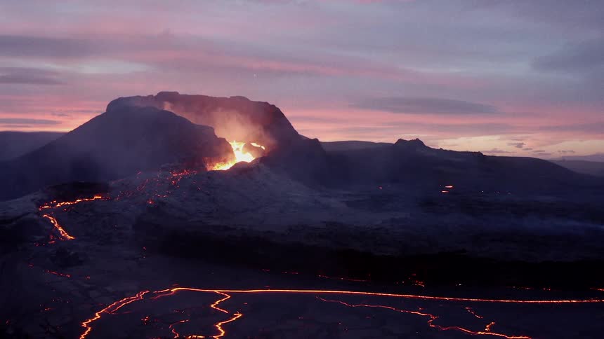 Lava flows from a volcano and onto a nearby road