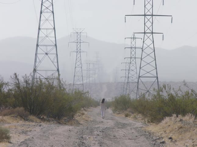 A woman walking down a path in the middle of the desert
