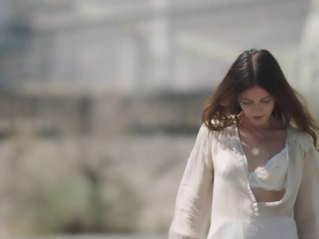 A woman walks slowly on a windy day