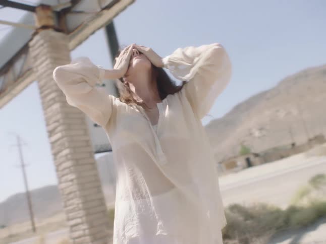 A woman is dancing outdoors in a rural area