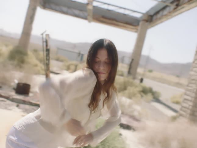 Young woman dancing inside an abandoned building in the desert
