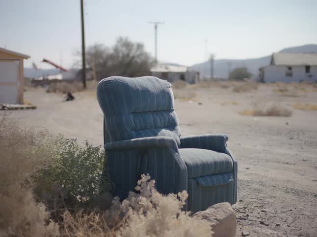 A recliner chair is lying outside in a countryside area