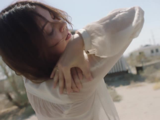 A woman dances in a neighborhood