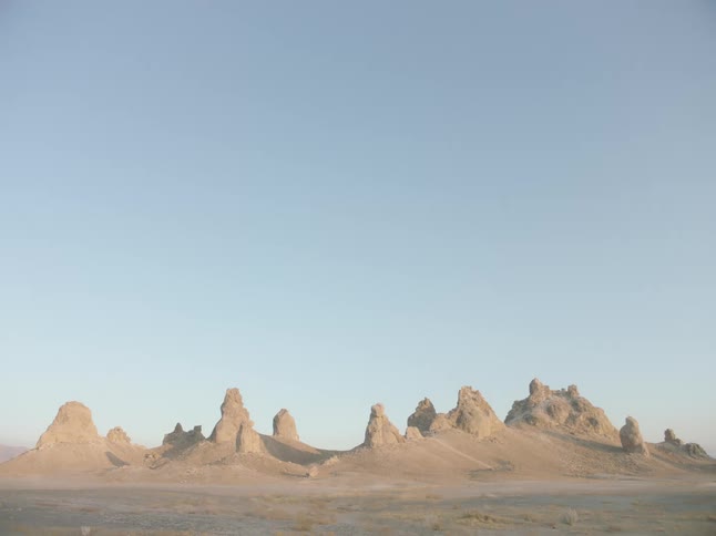 Desert borders badlands under clear blue sky