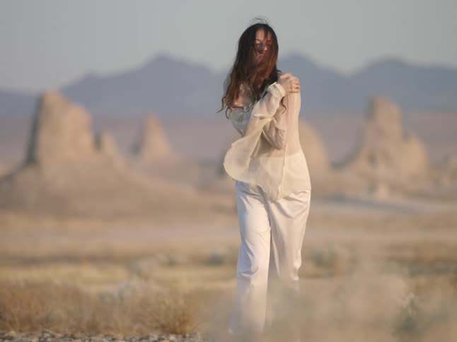 A woman is walking in the desert