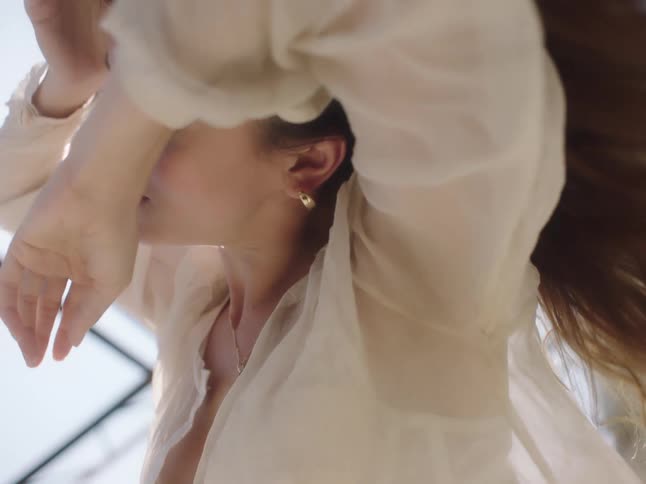 A woman is dancing outdoors during the day
