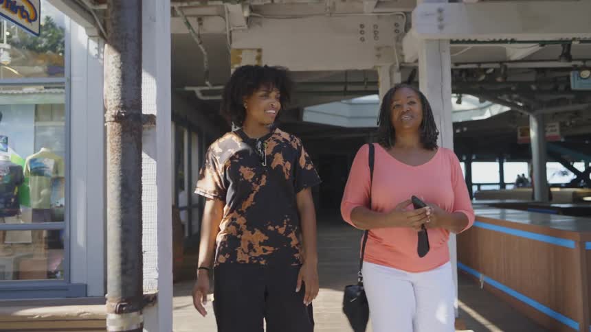 Two women walk and talk together