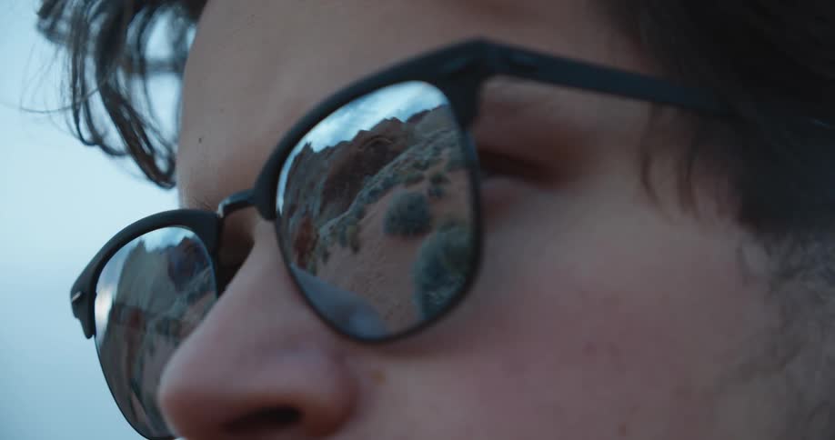A view of a mans sunglasses in the desert