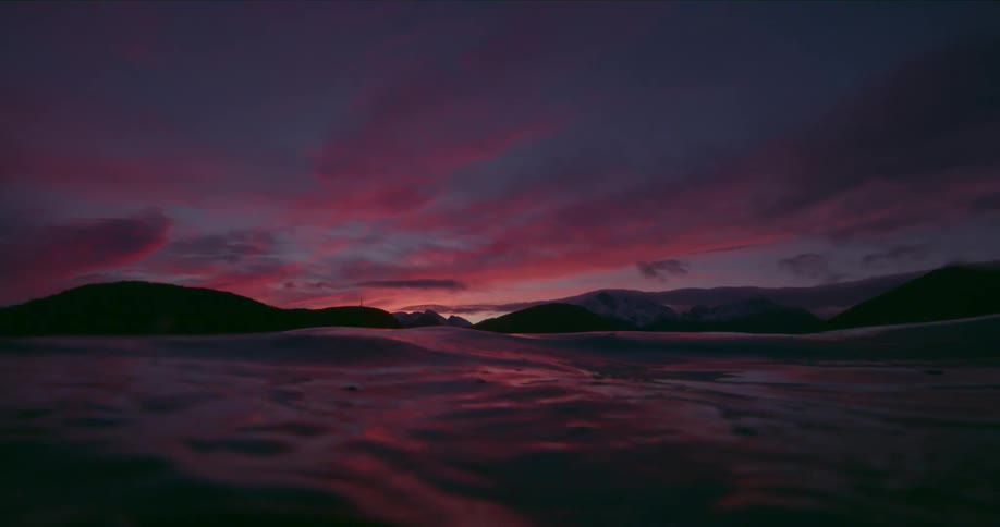 The sky is dark as rough waves move in the ocean