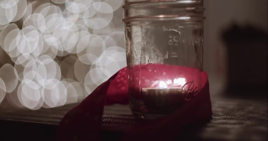 Close up of a candle burning in a jar