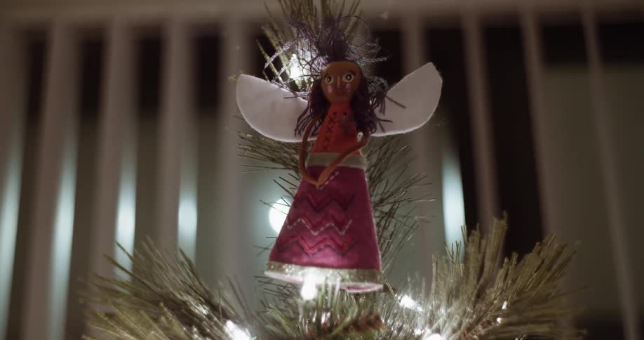 A angel is tied to the top of a christmas tree