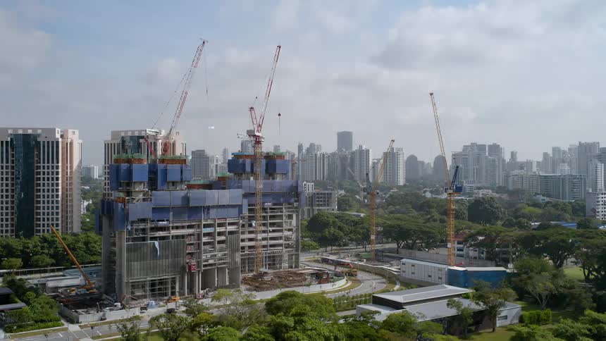 A time lapse shows a large building being constructed by multiple cranes