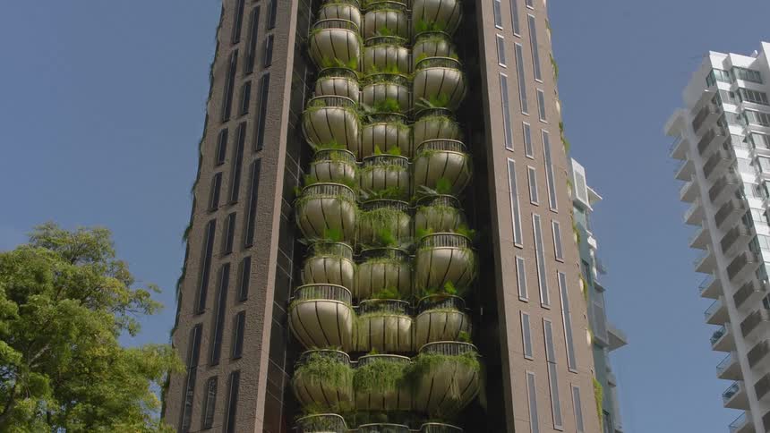 Apartment building with unique balcony design completes construction with plants growing