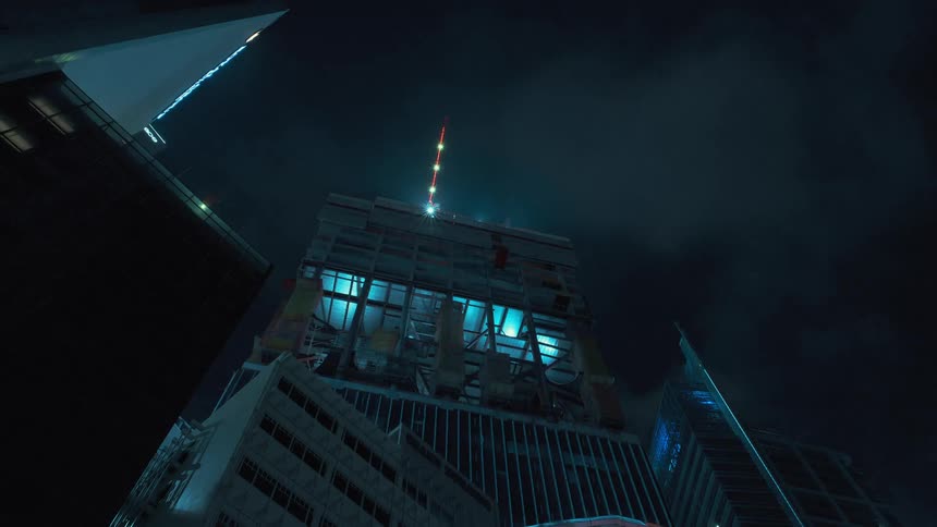 A time lapse shows a skyscraper being constructed by large cranes at night