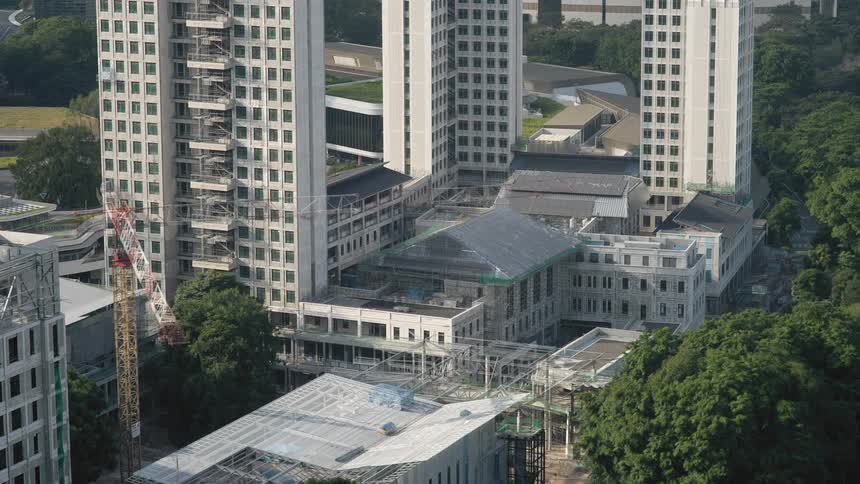 A time lapse shows a large building being built next to several taller buildings
