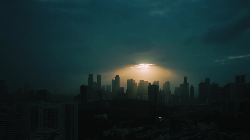 Sunlight peaks through dense clouds as the sun rises over downtown