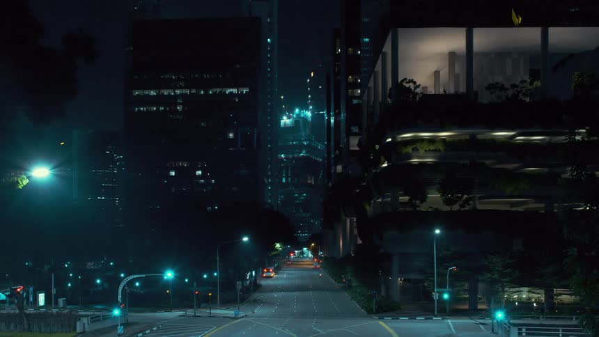 Skyscraper under construction rises at end of street as cars pass through intersection