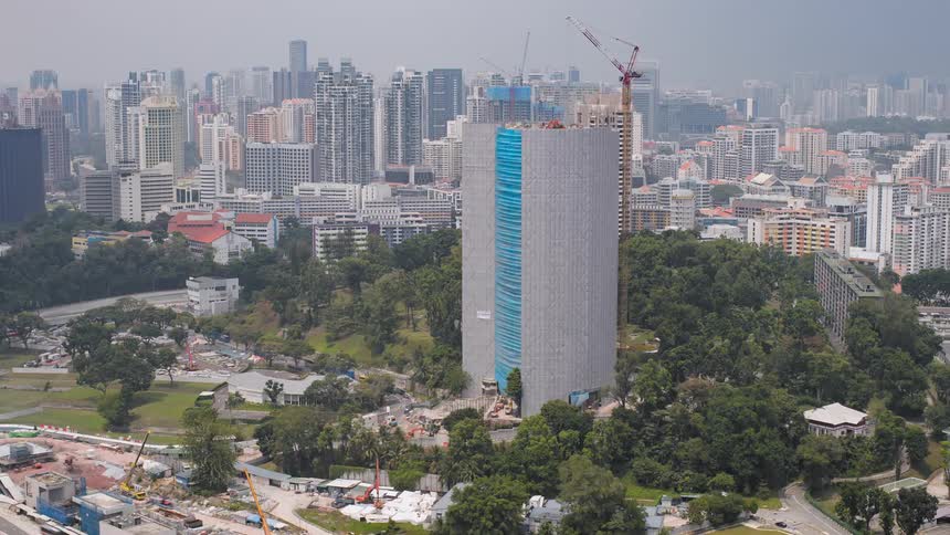 Building construction flows forward and in reverse in crowded city as construction cranes work and traffic passes
