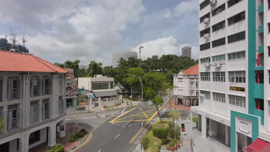 A skyscraper comes down as heavy traffic passes through a city neighborhood
