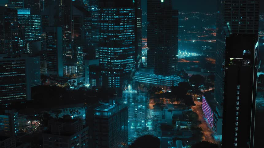The lights flash in the city at night as a building grows