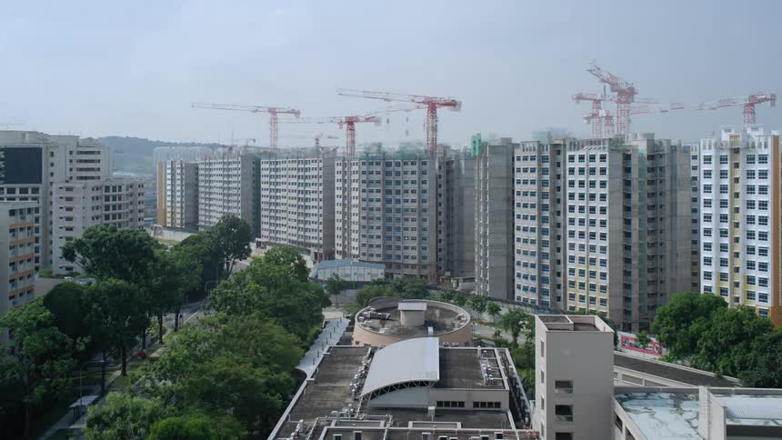 A city skyline with buildings and construction cranes with the sky in the background