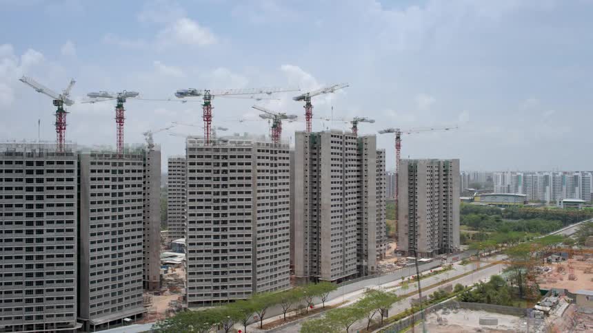 Workers and construction cranes build five buildings
