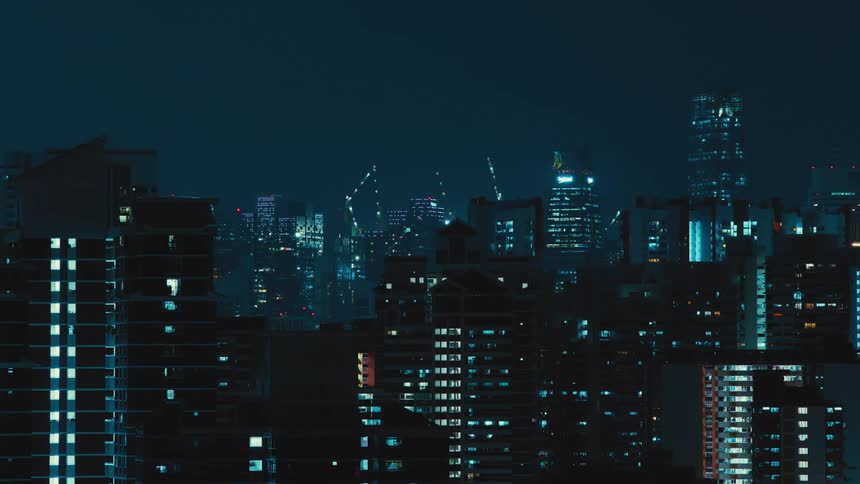 A city skyline with buildings and construction cranes with the sky in the background