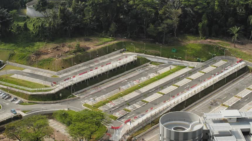 A construction site of a parking lot with vehicles with grass and trees in the background