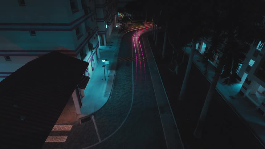 Car headlights and taillights are glowing dashes moving on a street at night