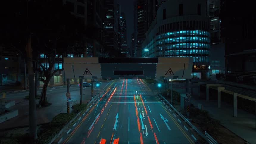 The buildings are lit at night as cars drive past