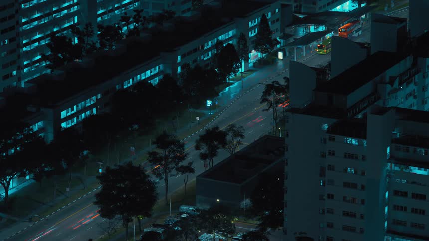 Multiple vehicles travel a city road at night