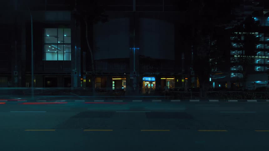 Bright lights on a street as a time lapse is taking of vehicles driving