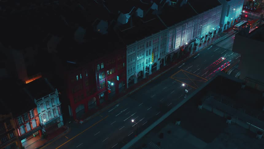 Traffic and pedestrians streak across and along street at night