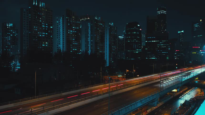 A time lapse shows the lights of cars driving along a freeway at night