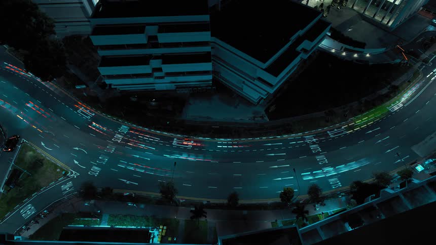 A time lapse shows numerous vehicles driving quickly along a large city street at night