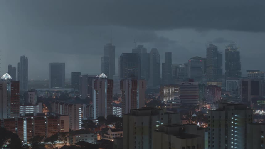 A time lapse shows daybreak and clouds passing over a metropolitan area filled with tall buildings