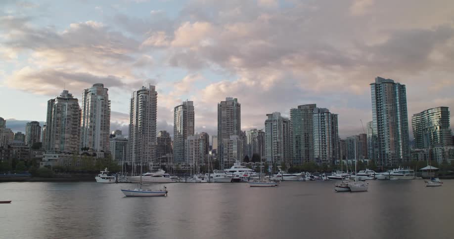 Time lapse of boats sailing in the water with Vancouver city skyline in the distance